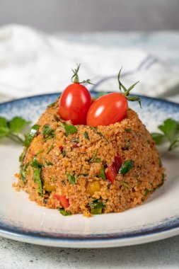 Gri arka planda Bulgur salatası. Geleneksel Türk Bulgur Salatası veya kisir Salatasi