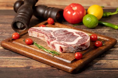 Dana pirzolası. Baharatlı ve biberiyeli taze et ve kalın pirzola. Özel pirzola. tahta arkaplan