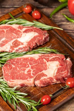 Sığır pirzolası. Baharatlı ve biberiyeli taze pirzola. Özel bir özet. Ahşap. Kapat.