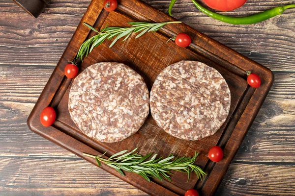Raw hamburger patties. Beef hamburger patties prepared with spices. Minced Beef burgers on cutting board. Top view