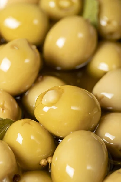 Cheese stuffed olives. Close-up pile of green olives with olive oil and spices