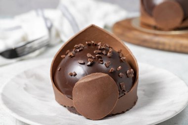 Küçük çikolatalı pasta. Pastane tatlıları. Lezzetli yuvarlak portakallı, kremalı ve dolgulu pasta. Kapat.