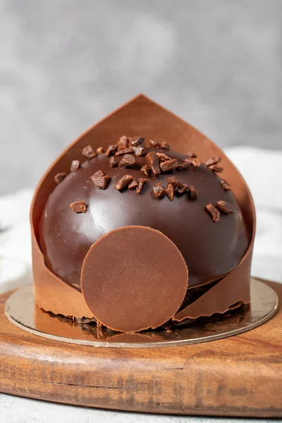 Chocolate portion cake. Bakery desserts. Delicious round portion cake with cream and dragee filling. Close up