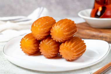 Tulumba tatlısı. Ramazan tatlısı. Geleneksel Türk mutfağı lezzetleri. Gri arka planda şuruplu Tulumba tatlısı. Kapat.
