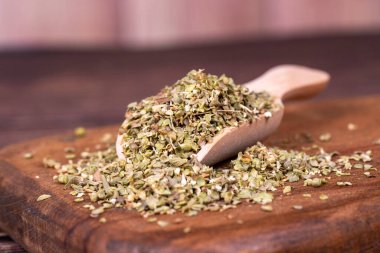 Kekik baharatı. Tahta arka planda ahşap kaşıkta kurumuş kekik yaprağı. Baharat konsepti. Kapat.