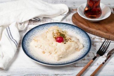 Ahşap arka planda Gullac tatlısı. Geleneksel Ramazan tatlısı. Çilekli ve fıstıklı Glla tatlısı.