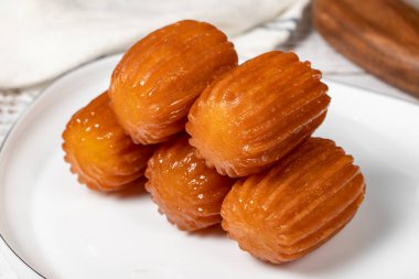 Ahşap zeminde Tulumba tatlısı. Geleneksel Ramazan tatlısı. Şerbetli Tulumba tatlısı. Kapat.