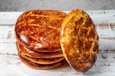 Ahşap zeminde susamlı ramazan pita. Ramazan yemekleri. Ramazan ayı için özel Pita ekmeği. Yerel adı Pastane Pidesi. Kapat.