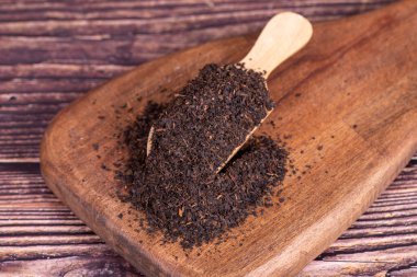 Siyah Türk çayı. Tahta arka planda kaşıkta siyah çay.