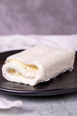 Gri arka planda pıhtılaşmış krem. Türk kahvaltısı için pıhtılaşmış krema. Yerel adı inek Kaymak. Kapat.