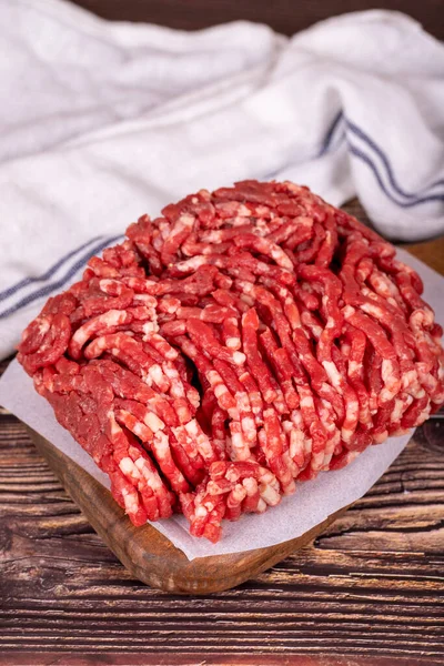 Minced meat on wood background. Raw minced cow meat or ground meat. Close up