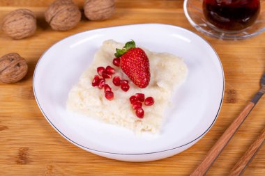 Nar ve çilekli Gullac tatlısı. Ramazan tatlısı. Ahşap arka planda cevizli Gullac tatlısı. Üst görünüm