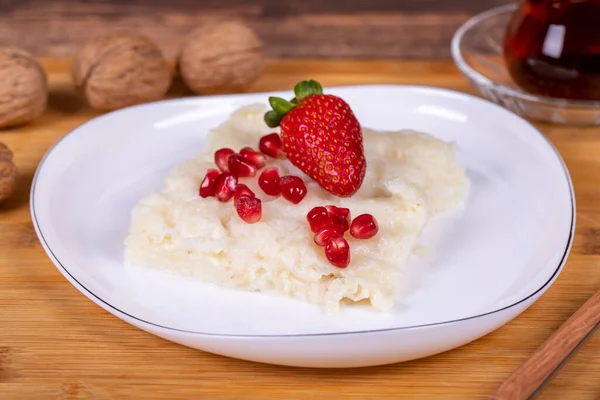 Nar ve çilekli Gullac tatlısı. Ramazan tatlısı. Ahşap arka planda cevizli Gullac tatlısı. Üst görünüm