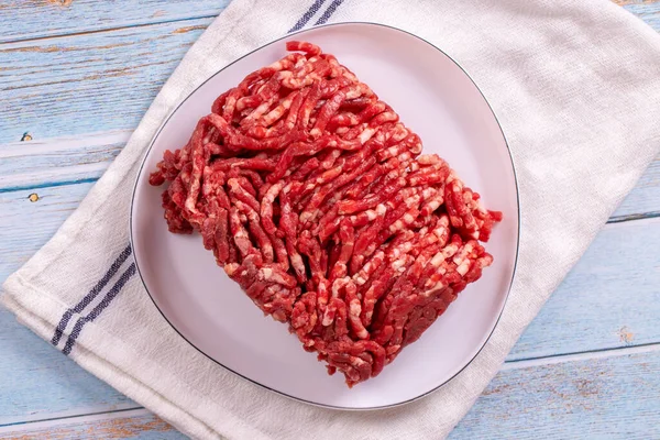 牛は皿の上でひき肉 木の背景に新鮮な挽肉 トップ表示 — ストック写真