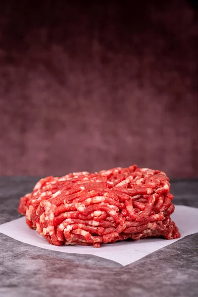 肉屋の紙にミンチ肉 木の背景に新鮮な挽肉 — ストック写真