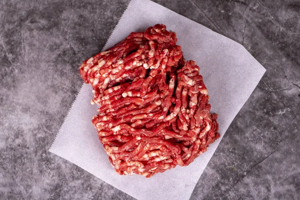 肉屋の紙にミンチ肉 木の背景に新鮮な挽肉 トップ表示 — ストック写真
