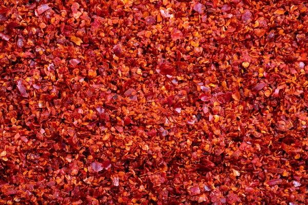 Dried red pepper flakes close-up. Spices and herbs. Chilli pepper seedless flakes background.