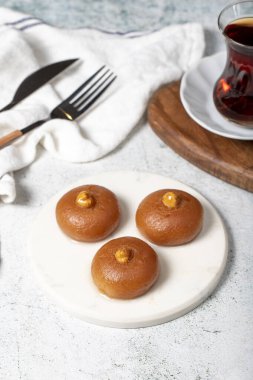 Sekerpare tatlı. Türk Ramazan tatlısı. Mermer servis tabağında şerbet ile Sekerpare tatlısı