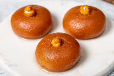 Sekerpare tatlı. Türk Ramazan tatlısı. Mermer servis tabağında şerbet ile Sekerpare tatlısı. Kapat.