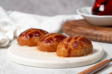 Sekerpare ya da badempare tatlı. Türk Ramazan tatlısı. Mermer servis tabağında şerbet ile Sekerpare tatlısı. Kapat.