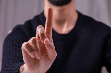 Genç adam işaret parmağını kaldırıyor..