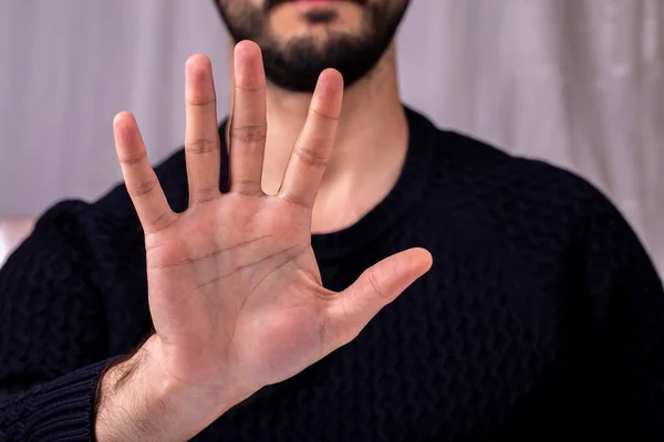Young man showing palm with five fingers. Concept of stop. five fingers in the hand