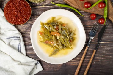 Ahşap zemin üzerinde zeytin yağı olan yeşil fasulye yemeği. Üst görünüm