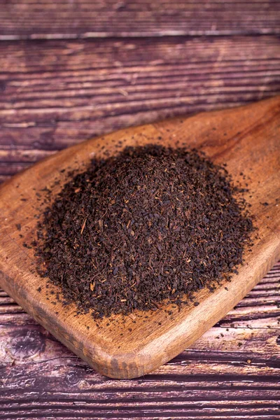 stock image Black tea. Dried black sea tea on wood background