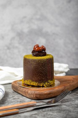 Çikolatalı pasta. Fıstıklı pasta ve koyu arkaplanda çikolata kreması. pastane tatlıları