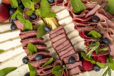 Antipasto tabağı. Soğuk füme et tabağı. Jambonlu Antipasto, jambon, salam, mavi peynir, yabanmersinli mozzarella ve çilekli. Üst görünüm
