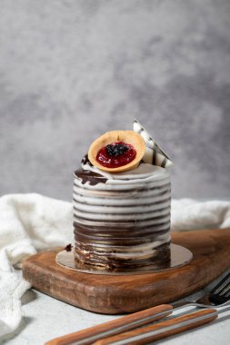 Çikolata kaplı kremalı pasta. Gri arka planda çikolatalı pasta. Stüdyo çekimi. Fırın ürünleri. Kapat.