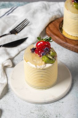 Çikolata kaplı kremalı pasta. Gri arka planda çikolatalı ve meyveli kek. Stüdyo çekimi. Fırın ürünleri