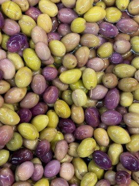 Yeşil ve mor zeytinler. Bir yığın organik zeytin. Kapatın. Yemek arkaplanı. Üst görünüm