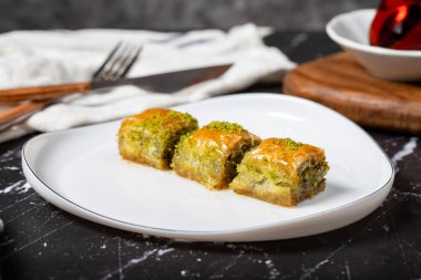 Siyah arka planda fıstıklı Baklava. Geleneksel Türk baklavası. Yerel adı Ankara Sarmasi. Kapat.