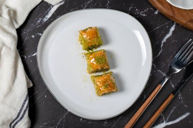 Siyah arka planda fıstıklı Baklava. Geleneksel Türk baklavası. Yerel adı Ankara Sarmasi. Üst görünüm