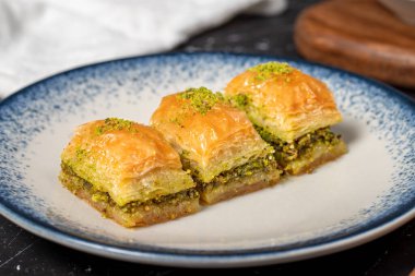 Siyah arka planda fıstıklı Baklava. Geleneksel Türk baklavası. Kapat.