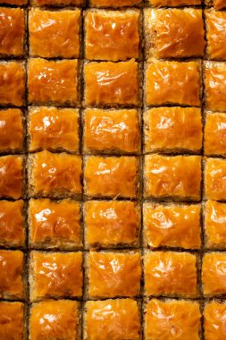 Ahşap zeminde fıstıklı baklava. Bir tepsi baklava. Geleneksel Türk mutfağı lezzetleri. Şerbet tatlısı. Üst görünüm