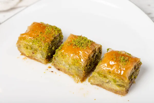 stock image Baklava with pistachio on a wood background. Traditional Turkish baklava. Local name ankara sarmasi. Close up