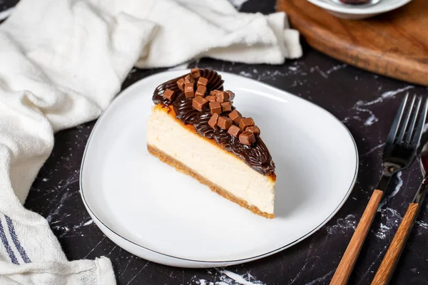 Chocolate cheesecake on dark background. Delicious cheesecake with chocolate chips and cream