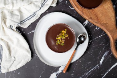 Çikolata süslemeli tatlı. Kremalı ve çikolatalı puding ya da koyu arkaplanda süper tatlı. Üst görünüm