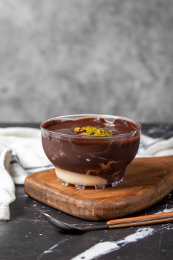 Çikolata süslemeli tatlı. Kremalı ve çikolatalı puding ya da koyu arkaplanda süper tatlı. Kapat.