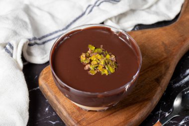 Çikolata süslemeli tatlı. Kremalı ve çikolatalı puding ya da koyu arkaplanda süper tatlı. Kapat.