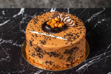 Karamelli kremalı pasta. Doğum günü ya da kutlama pastası. Koyu arkaplanda karamel ve çikolata kremalı kek..