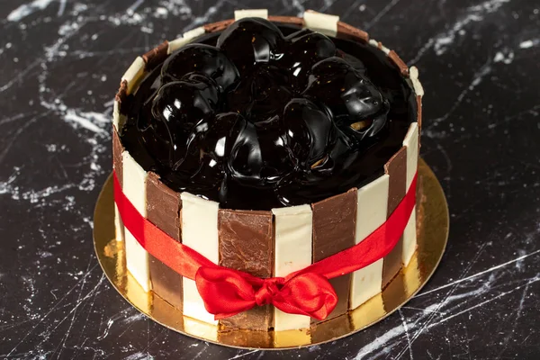 配上色拉和巧克力奶油的蛋糕 生日或庆祝蛋糕 在深色的背景上涂上胡椒粉和黑巧克力奶油的蛋糕 靠近点 — 图库照片