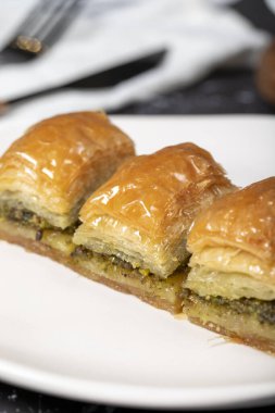 Fıstıklı baklava. Koyu arkaplanda şerbetli Pistachio baklava. Türk mutfağı lezzetleri. Kapat.