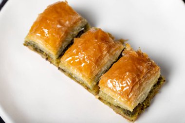 Fıstıklı baklava. Koyu arkaplanda şerbetli Pistachio baklava. Türk mutfağı lezzetleri. Kapat.