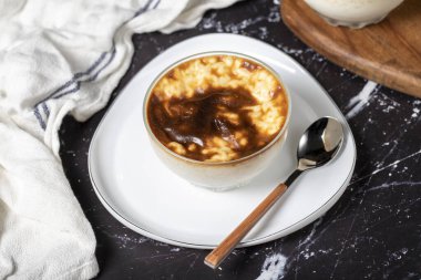 Siyah arka planda sütlaç. Sütlü sütlü sütlü sütlü tatlı. Türk mutfağı lezzetleri