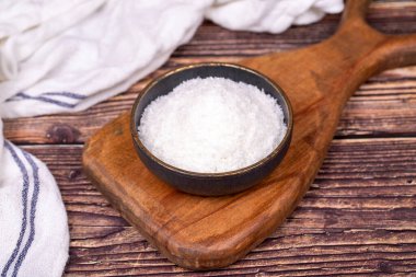 Hindistan cevizi tozu. Ahşap zeminde öğütülmüş hindistan cevizi taneleri. Koyu renkli hindistan cevizi kasesi.