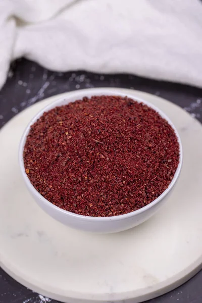 stock image Sumac on dark background. Dried ground red Sumac powder spices in wooden bowl. Close up