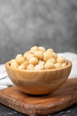 Macadamia fındığı. Tahta kasede Macadamia fındığı. Süper yemek. Vejetaryen gıda konsepti. Sağlıklı atıştırmalıklar. Kapat.